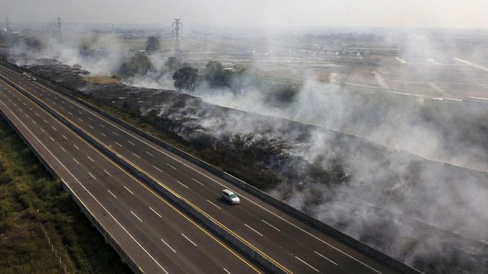 Kebakaran melanda tempat pembuangan sampah (TPS) ilegal di sebelah Jalan Tol Cibitung - Cilincing, Kabupaten Bekasi, Jawa Barat, Minggu (24/9) lalu. Saat ini asap sisa kebakaran masih mengepul di TPS ilegal tersebut.