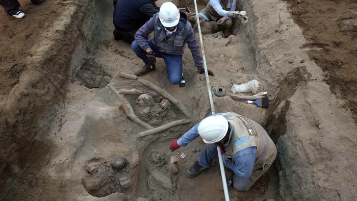 Archaeologists uncover bones and vessels discovered by city workers who were digging a natural gas line for the company Calidda in the district of Carabayllo on the outskirts of Lima, Peru, Friday, Sept. 22, 2023. Eight burial offerings from the pre-Inca Ychsma culture have been identified by archeologists so far, according to lead archeologist Jesus Bahamonde. The tube running through the site is an illegal water pipe. (AP Photo/Martin Mejia)