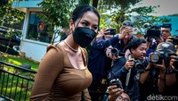 Siskaeee memakai busana bertema earth tone, masker, dan kacamata.  