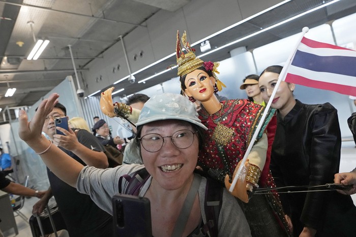 Chinese tourists dance with puppet as Chinese tourists are welcomed on the arrivals at Suvarnabhumi International Airport in Samut Prakarn province, Thailand, Monday, Sept. 25, 2023. Thailands new government granting temporary visa-free entry to Chinese tourists, signaling that the recovery of the countrys tourism industry is a top economic priority. (AP Photo/Sakchai Lalit)