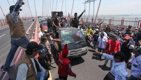 Massa yang tergabung dalam MADAS berunjuk rasa di Jembatan Suramadu, Surabaya, Jawa Timur, Senin (25/9/2023).  