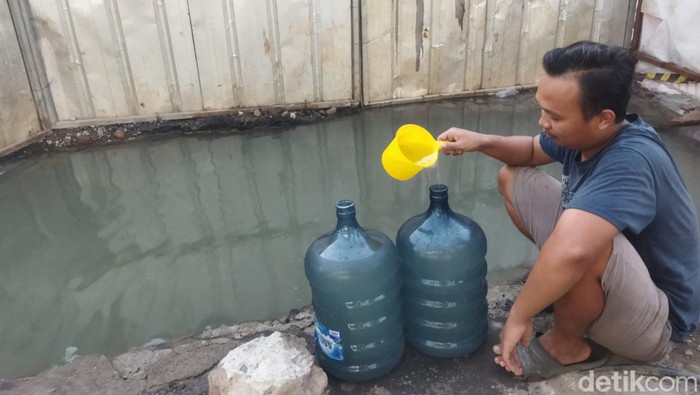 Warga di Bekasi ambil air dari kubangan pipa PDAM. (Kurniawan/detikcom)