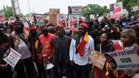 Beberapa demonstran mengibarkan plakat atau bendera Ghana. Mereka mengecam tingginya biaya hidup dan kurangnya lapangan kerja.  