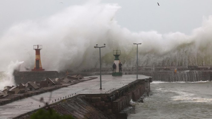 People look at large waves crashing against the Kalk Bay harbour wall during severe weather conditions in Cape Town, South Africa, September 24, 2023. REUTERS/Esa Alexander