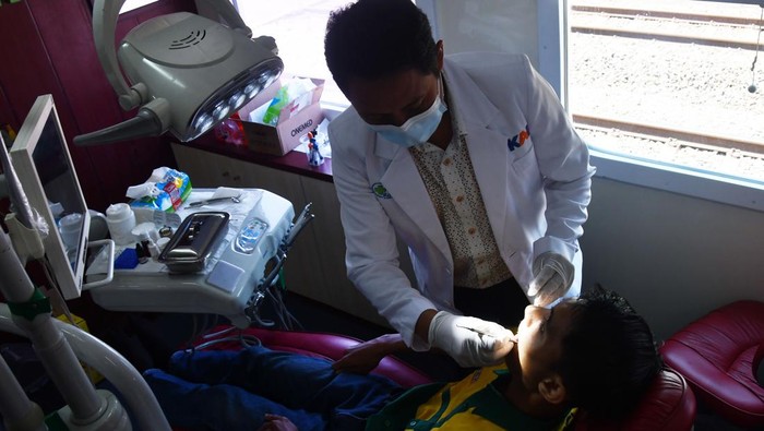 Dokter gigi memeriksa gigi warga saat bakti sosial layanan kesehatan kereta sehat (rail clinic) 2023 oleh PT KAI (Persero) Daerah Operasi 7 Madiun di Stasiun Kereta Api Caruban, Kabupaten Madiun, Jawa Timur, Selasa (26/9/2023). Kegiatan dalam rangka HUT ke-78 KAI serta program Tanggung Jawab Sosial dan Lingkungan PT KAI tersebut mengundang 200 orang warga di sekitar stasiun yang perlu mendapatkan layanan kesehatan gratis, antara lain meliputi poli umum, gigi, mata, kandungan serta pemberian obat-obatan. ANTARA FOTO/Siswowidodo/tom.
