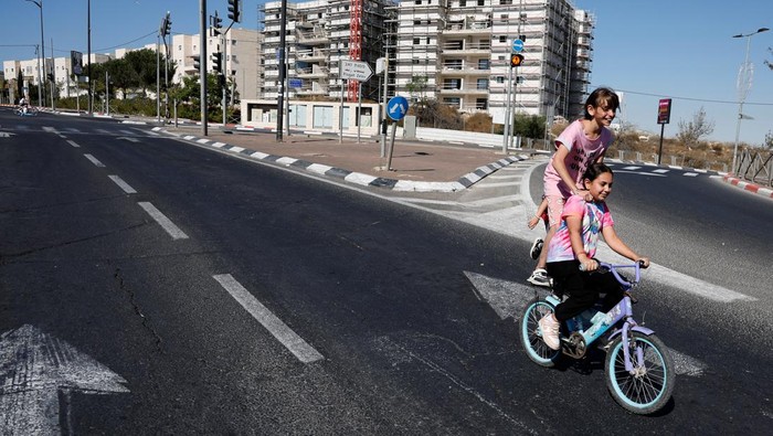 Youngsters ride bicycles along a deserted street on Yom Kippur, the Jewish day of atonement and the holiest day in the Jewish calendar, in Jerusalem September 25, 2023. REUTERS/Ammar Awad