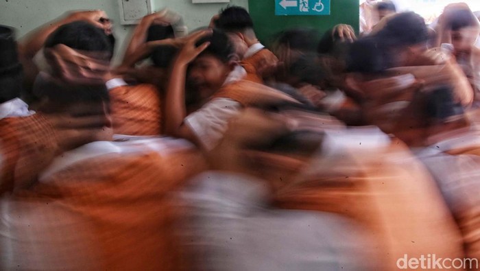 Para siswa MTS 9 Johar Baru, Jakarta Pusat, belajar sosialisasi penanggulangan bencana alam dan kebakaran. Saat simulasi gempa, meeka sembunyi di bawah meja.