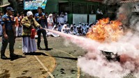 Tampak seorang siswa belajar memadamkan api dengan hydrant.  