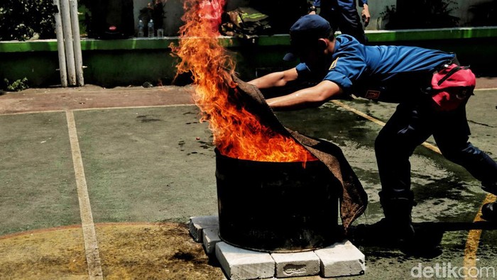 Para siswa MTS 9 Johar Baru, Jakarta Pusat, belajar sosialisasi penanggulangan bencana alam dan kebakaran. Saat simulasi gempa, meeka sembunyi di bawah meja.
