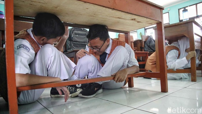 Simulasi Bencana Gempa, Pelajar Sembunyi di Bawah Meja Para siswa MTS 9 Johar Baru, Jakarta Pusat, belajar sosialisasi penanggulangan bencana alam dan kebakaran. Saat simulasi gempa, meeka sembunyi di bawah meja.