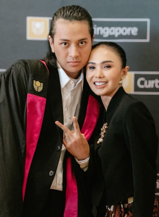 Hadir di wisuda putra pertamanya, wanita bersuara merdu itu tampil anggun dan cantik dengan rambut tersanggul. Penampilannya kala berfoto bersama Cavin pun sukses mencuri atensi. Foto: Instagram/@yunishara36