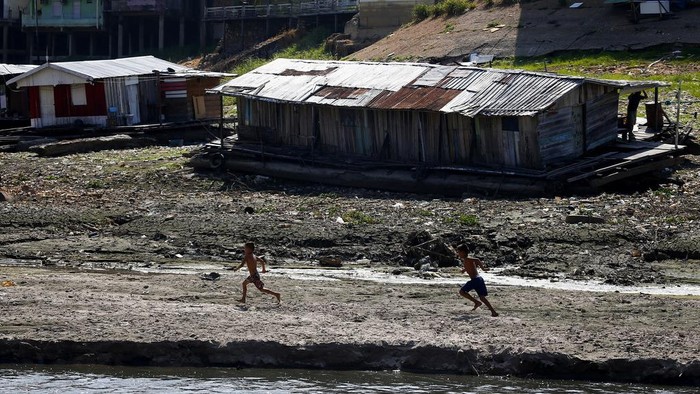 Houseboats, boats and trash lay on the now dry area that used to be covered by the Negro river, next to the river wall in Manaus, Brazil, Tuesday, Sept. 26, 2023. The Brazilian Amazon rainforest is facing a severe drought that may affect around half a million people by the end of the year, authorities said Tuesday. (AP Photo/Edmar Barros)