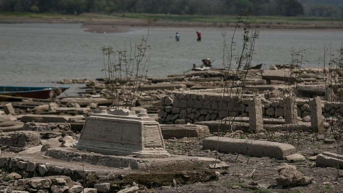 Makam Kuno Muncul dari Waduk Gajah Mungkur yang Mengering Warga mencari ikan di dekat area pemakaman lama di Waduk Gajah Mungkur yang mengering di Wuryantoro, Wonogiri, Jawa Tengah, Jumat (15/9/2023). Sejumlah makam lama milik warga yang rumahnya tergusur proyek pembangunan waduk Gajah Mungkur seluas 8.800 hektar, menenggelamlamkan 51 desa di tujuh kecamatan pada 1976-1980 tersebut muncul dan terlihat pada musim kemarau saat volume air waduk menyusut. ANTARA FOTO/Mohammad Ayudha/Spt.