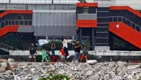 Mereka bermain layang-layang bersama di lahan kosong tersebut.