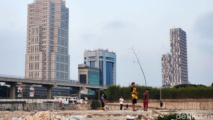 Serunya Main Layangan di Lahan Kosong Ibu Kota Anak-anak bermain layangan di lahan kosong yang masih belum dibangun, di samping Stasiun LRT Pancoran, Jakarta Selatan, Rabu (27/9/2023). Sebagian lain menggunakan ranting pohong untuk mengejar layangan putus. Kebutuhan ruang terbuka yang dekat dengan permukiman untuk beraktivitas dan berinteraksi terus meningkat.