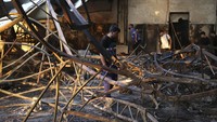 Sejumlah warga membersihkan sisa puing-puing bangunan di lokasi kebakaran di Nineveh, Irak, Rabu (27/9/2023).