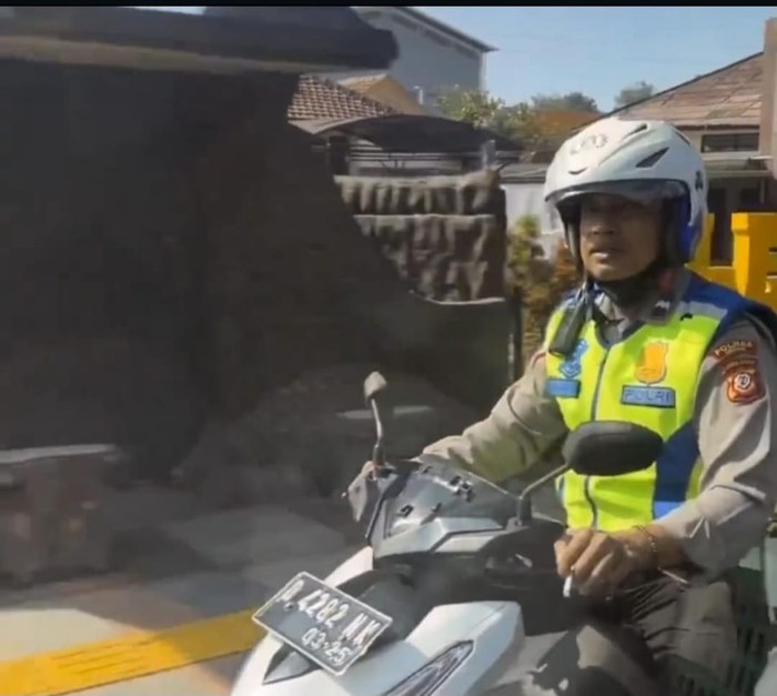 Viral seorang polantas mengendarai motor sambil merokok.