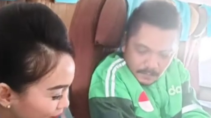 Viral video pramugari memastikan boarding pass seorang pria dengan jaket ojek online (ojol) di pesawat.