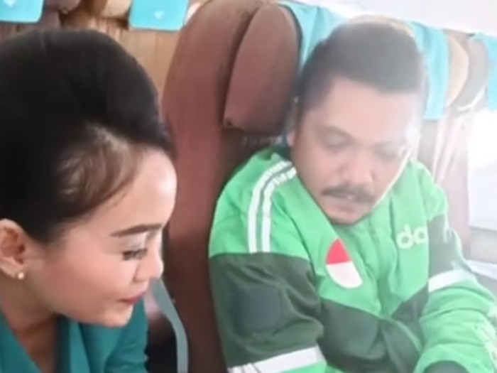 Viral video pramugari memastikan boarding pass seorang pria dengan jaket ojek online (ojol) di pesawat.