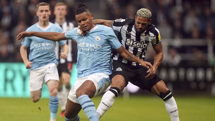 Manchester Citys Manuel Akanji, left, and Newcastle Uniteds Joelinton, right, battle for the ball during the English League Cup soccer match between Newcastle United and Manchester City in Newcastle upon Tyne, England, Wednesday, Sept. 27, 2023. (Owen Humphreys/PA via AP)