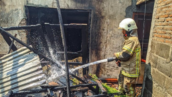 Petugas Damkar Klaten menyemprotkan air ke rumah yang dibakar pemuda di Desa Kadibolo, Kecamatan Wedi, Klaten. Kamis (28/9/2023).