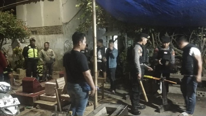 Polisi saat menggerebek arena adu kemiri di komplek pemakaman umum.