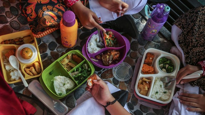 Siswa memperlihatkan menu makanannya saat mengikuti program gerakan makan bergizi di SDN Pekunden, Semarang, Jawa Tengah, Jumat (29/9/2023). Kegiatan makan bersama dengan menu lauk bergizi seperti tempe, tahu, daging, telur, sayuran dan susu tersebut rutin diadakan pihak sekolah sebagai upaya pemenuhan gizi protein nabati dan hewani sehingga erhindar dari masalah stunting serta menghasilkan generasi yang lebih unggul. ANTARA FOTO/Makna Zaezar/Spt.