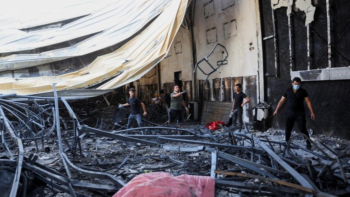 Volunteers search for the remains of missing bodies following a fatal fire at a wedding celebration, in the district of Hamdaniya, in Nineveh province, Iraq, September 28, 2023. REUTERS/Ahmed Saad