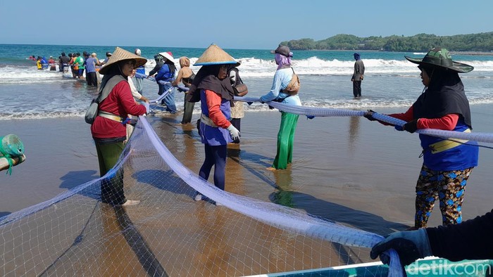 Nelayan menarik jaring arad di Pantai Batukeras