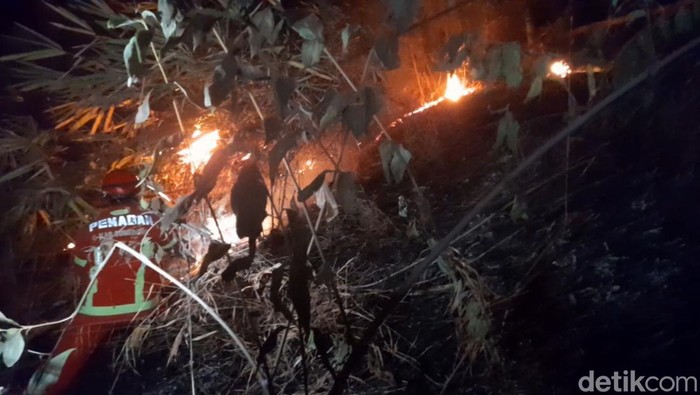 Petugas berusaha memadamkan kobaran api di Bukit Baginda, Sumedang.