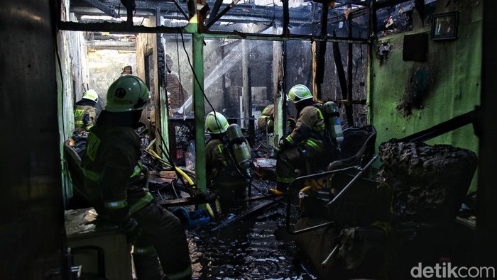 Petugas pemadam kebakaran dan warga bahu membahu memadamkan api yang membakar perumahan di Jl Anyer, RT 006/009 Menteng, Jakarta Pusat, Jumat (29/9/2023).