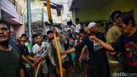 Warga pun bahu membahu bersama petugas pemadam kebakaran untuk memadamkan api.  