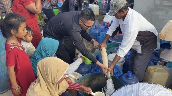 Anggota Bataliyon C Pelopor Brimob Polda Sultra menyalurkan air bersih kepada warga.