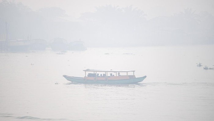 Jam Belajar Sekolah di Palembang Dikurangi Gegara Kabut Asap Sejumlah pelajar berangkat sekolah menggunakan perahu tradisional melewati kawasan yang diselimuti kabut asap di Sungai Ogan, Palembang, Sumatera Selatan, Sabtu (30/9/2023). Dinas Pendidikan Kota Palembang mengurangi waktu kegiatan belajar siswa TK,SD dan SMP mulai pukul 09:00 WIB dan meniadakan kegiatan di luar kelas seperti olahraga, upacara, ekstrakurikuler akibat dampak buruk bencana kabut asap yang melanda Kota Palembang. ANTARA FOTO/Nova Wahyudi/rwa.