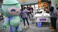 Seorang jurnalis berfoto dengan Lianlian maskot Asian Games 2022 di Main Press Center (MPC), Hangzhou, China, Sabtu (30/9/2023). 