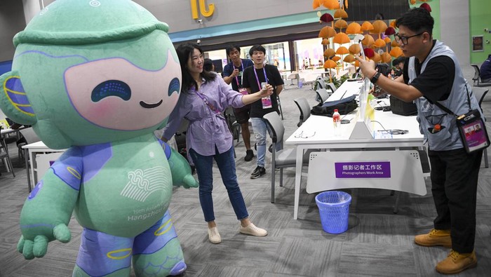 Kenalan dengan Lianlian, Maskot Asian Games 2023 Seorang jurnalis berfoto dengan Lianlian maskot Asian Games 2022 di Main Press Center (MPC), Hangzhou, China, Sabtu (30/9/2023). Lianlian salah satu dari tiga maskot robot dari Asian Games Hangzhou 2022 selain Congcong dan Chenchen yang menjadi simbol dari semangat Olimpiade, perdamaian, dan persahabatan. ANTARA FOTO/M Risyal Hidayat/rwa.