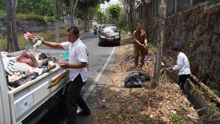 Pemkot Batu memungut sampah yang dibuang sembarangan di pinggir jalan.