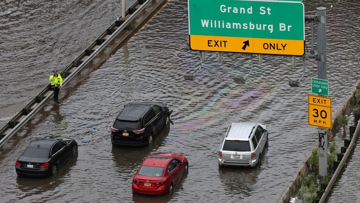 Penampakan Banjir di New York Akibat Curah Hujan Tinggi A police officer stands as he assists motorists stuck on a flooded street after heavy rains as the remnants of Tropical Storm Ophelia bring flooding across the mid-Atlantic and Northeast, at the FDR Drive in Manhattan near the Williamsburg Bridge, in New York City, U.S., September 29, 2023. REUTERS/Andrew Kelly