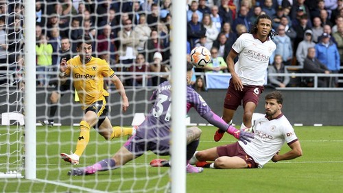 Wolverhampton Wanderers Pedro Neto, left, looks on as his cross is turned into an own goal by Manchester Citys Ruben Dias during the English Premier League soccer match between Wolverhampton Wanderers and Manchester City at Molineux Stadium, Wolverhampton, England, Saturday Sept. 30, 2023. (Nick Potts/PA via AP)