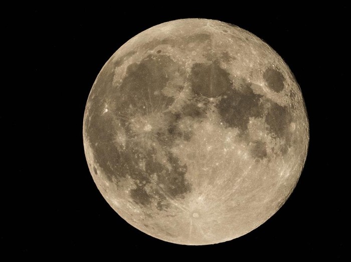 An exhaust pipe from a diesel generator spouts fumes as the September full moon, known as the Harvest Moon, rises in the background, in Beirut, Lebanon, Friday, Sept. 29, 2023. (AP Photo/Hassan Ammar)