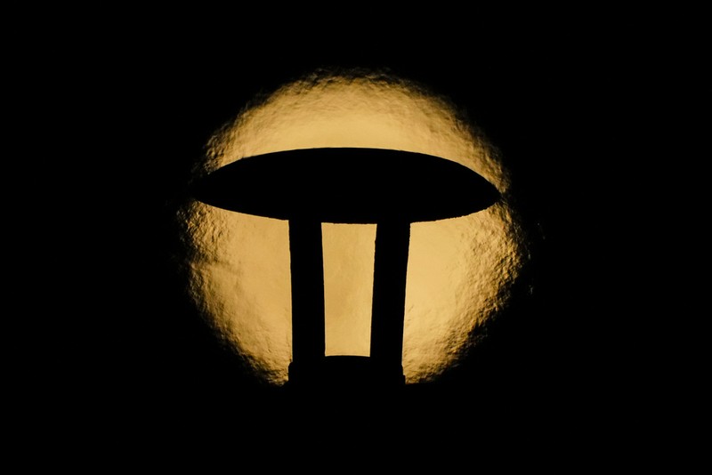 An exhaust pipe from a diesel generator spouts fumes as the September full moon, known as the Harvest Moon, rises in the background, in Beirut, Lebanon, Friday, Sept. 29, 2023. (AP Photo/Hassan Ammar)