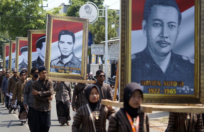 Sejumlah peserta berjalan membawa foto pahlawan revolusi saat Kirab Merah Putih di Kabupaten Batang, Jawa Tengah, Minggu (1/10/2023). Kirab merah putih dalam rangka memperingati Hari Kesaktian Pancasila itu, diikuti sekitar 4.500 orang yang mengarak foto pahlawan revolusi dan bendera merah putih sepanjang sekitar satu kilometer yang bertujuan untuk mengenang jasa pahlawan revolusi dan meningkatkan ideologi bangsa kepada seluruh lapisan masyarakat. ANTARA FOTO/Harviyan Perdana Putra