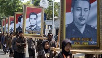Sejumlah peserta berjalan membawa foto pahlawan revolusi saat Kirab Merah Putih di Kabupaten Batang, Jawa Tengah, Minggu (1/10/2023). 