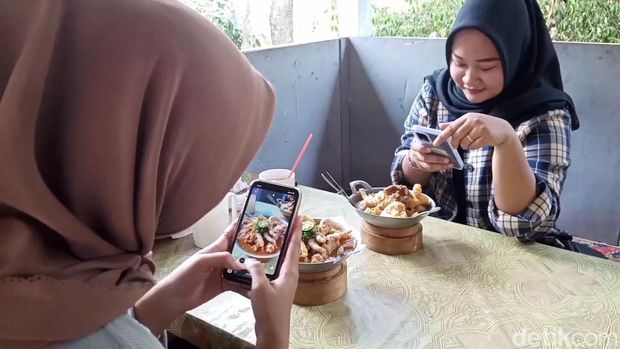 Menikmati seblak pedas yang disajikan di wajan mini.