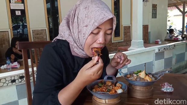 Menikmati seblak pedas yang disajikan di wajan mini.