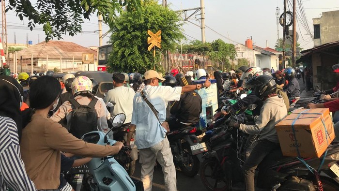 Nila Nur Akidah mengurai ruwetnya macet di lintasan sebidang di dekat Stasiun Pondok Jati, Matraman, Jakarta Pusat. (Fitrya Anugrah/detikcom)