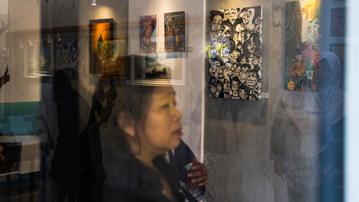 Pengunjung mengamati karya lukisan yang dipajang pada pameran bertajuk Gumregah di Tan Artspace, Semarang, Jawa Tengah, Minggu (1/10/2023). Pameran mengusung tagline semangat untuk bangkit yang berlangsung hingga 12 Oktober 2023 itu menampilkan 30 karya seni lukis murni dari 16 seniman perempuan anggota Women Painter Community Semarang yang menceritakan tentang kebebasan menuangkan cerita pribadi dalam komposisi dan sapuan kuas. ANTARA FOTO/Makna Zaezar/nz