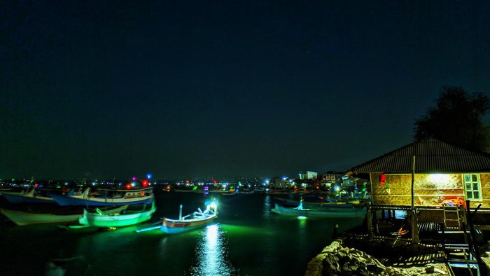 Pemandangan di tepi dermaga dengan lampu-lampu perahu milik nelayan Desa Pulau Maringkik, Lombok Timur, yang berkedip. (Ahmad Viqi)