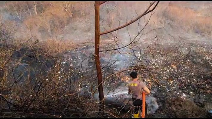 Polisi Memadamkan Api di Perbukitan dekat Kampung Adat Cireundeu yang Terbakar