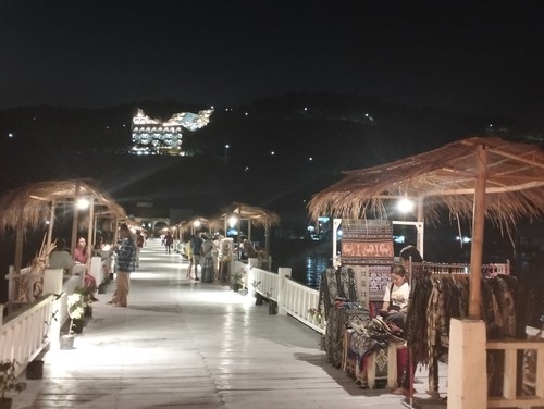 Sejumlah wisatawan berburu suvenir di Dermaga Putih Labuan Bajo pada malam hari, Minggu (1/10/2023). (Ambrosius Ardin)